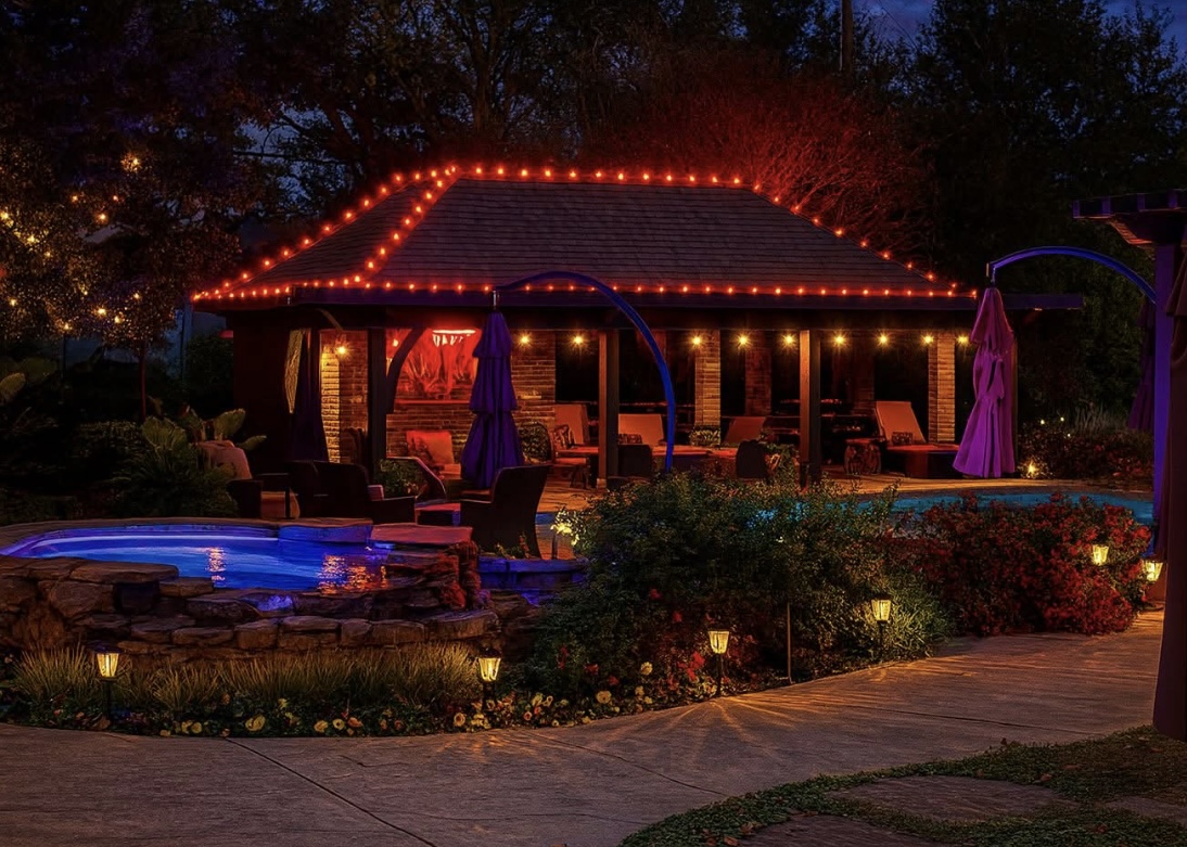 Backyard pavilion and pool glowing with red holiday lights